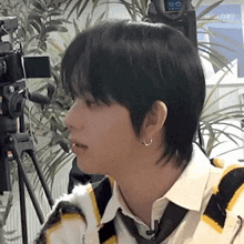 a close up of a person 's face with a camera behind him