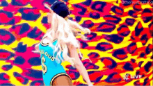 a woman in a blue jersey is dancing in front of a colorful background .