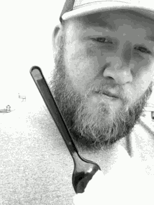a man with a beard holds a plastic spoon in his hand
