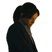 a woman in a suit and ponytail looks down