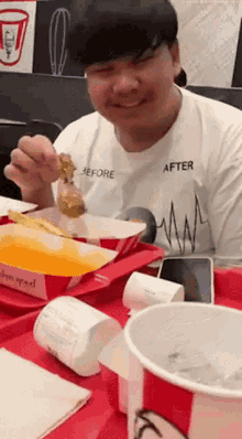 a man wearing a white shirt that says before and after is eating chicken