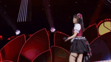 a woman in a red and black dress is dancing on a stage .