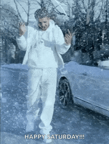 a man in a white suit is dancing in the snow with the words happy saturday written below him