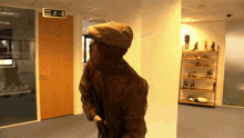 a person walking in a hallway with a fire exit sign
