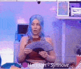 a woman with blue hair is holding a fan and the name hannah is on the bottom of the screen