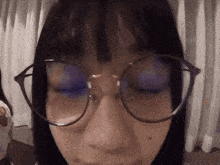 a close up of a person wearing glasses with their eyes closed