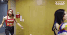 two women are standing next to each other in a room and dancing .