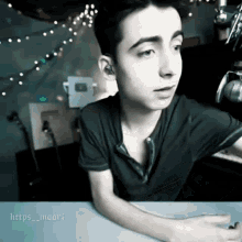 a young man is sitting at a table with a microphone in front of him