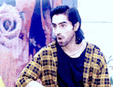 a man wearing a plaid shirt and a black shirt has his mouth open