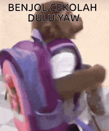 a person carrying a child with a backpack that says benjol sekolah dulu yaw on it