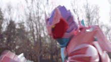 a close up of a person in a pink and purple costume with a helmet on .