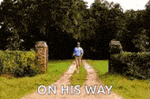 a man is running down a dirt road with the words `` on his way '' written on the side .