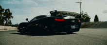 a black sports car with the word koenigsegg on the wing