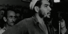 a black and white photo of a man speaking into a microphone