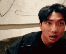 a man is sitting on a couch with his mouth open and making a funny face .