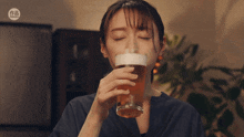 a woman drinking a glass of beer with a sticker that says taiwan