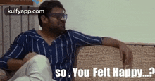 a man is sitting on a couch wearing sunglasses and a striped shirt and says `` so , you felt happy ? ''