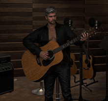 a man in a black shirt is holding an acoustic guitar in front of two microphones