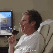 a man is sitting in a chair holding a glass of wine and making a funny face .