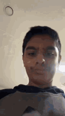 a young boy is making a funny face while wearing a hoodie .