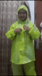 a woman wearing a neon yellow raincoat is standing in front of a door .