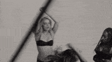 a woman in a bikini is standing in front of a drum with the letter e on it