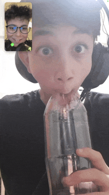 a boy wearing glasses and headphones is drinking from a plastic bottle