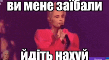 a man in a red shirt is singing into a microphone with a caption in russian