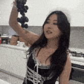 a woman in a maid costume is holding a bunch of grapes in her hand