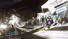 a ski jumper is jumping over a veryvox advertisement
