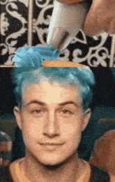 a close up of a person 's face with a cupcake in the background