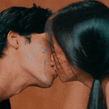 a man and a woman kiss with a heart drawn on their faces