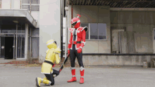 a man in a red and yellow costume kneeling down next to another man in a yellow costume
