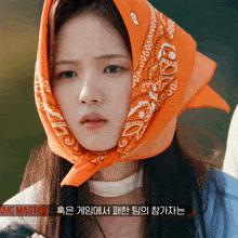 a woman wearing an orange bandana on her head with the word game master written below her