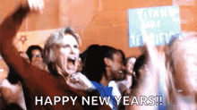 a woman in a crowd shouts happy new years in front of a sign that says titans park tennis