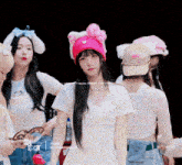 a girl wearing a pink hello kitty hat and a white shirt that says triples