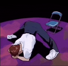a man is laying on his back on a purple floor next to a chair .