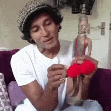 a man sitting on a couch holding a red object
