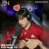 a man wearing headphones sits in front of a microphone that says t98 on the front