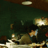 a man sits at a desk with his head in his hands in front of a painting that says let 's go wild