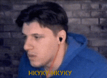 a man wearing headphones and a blue hoodie is talking in a video chat .