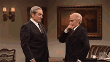 two men in suits and ties are standing next to each other in front of a framed painting that says snl