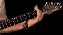 a person playing a kiesel electric guitar