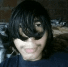 a close up of a person 's face with long black hair and sunglasses on .
