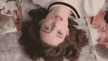 a woman laying on her stomach with a magazine in the background