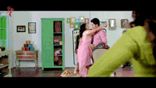 a man and a woman are dancing in a room with a green wardrobe