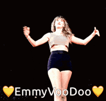 a woman in a crop top and shorts is dancing with the words emmy voodoo behind her
