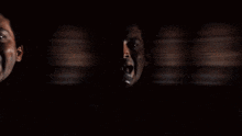 a blurry picture of a man singing into a microphone with a reflection of himself