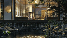 a couple standing outside of a house near a river