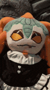 a stuffed animal wearing a black and white dress with hearts on the buttons